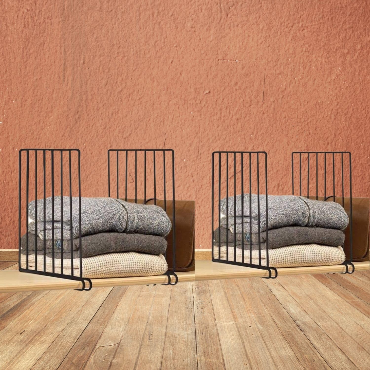 Go Hooked black metal shelf dividers organize stacks of folded sweaters and blankets on a wooden shelf.