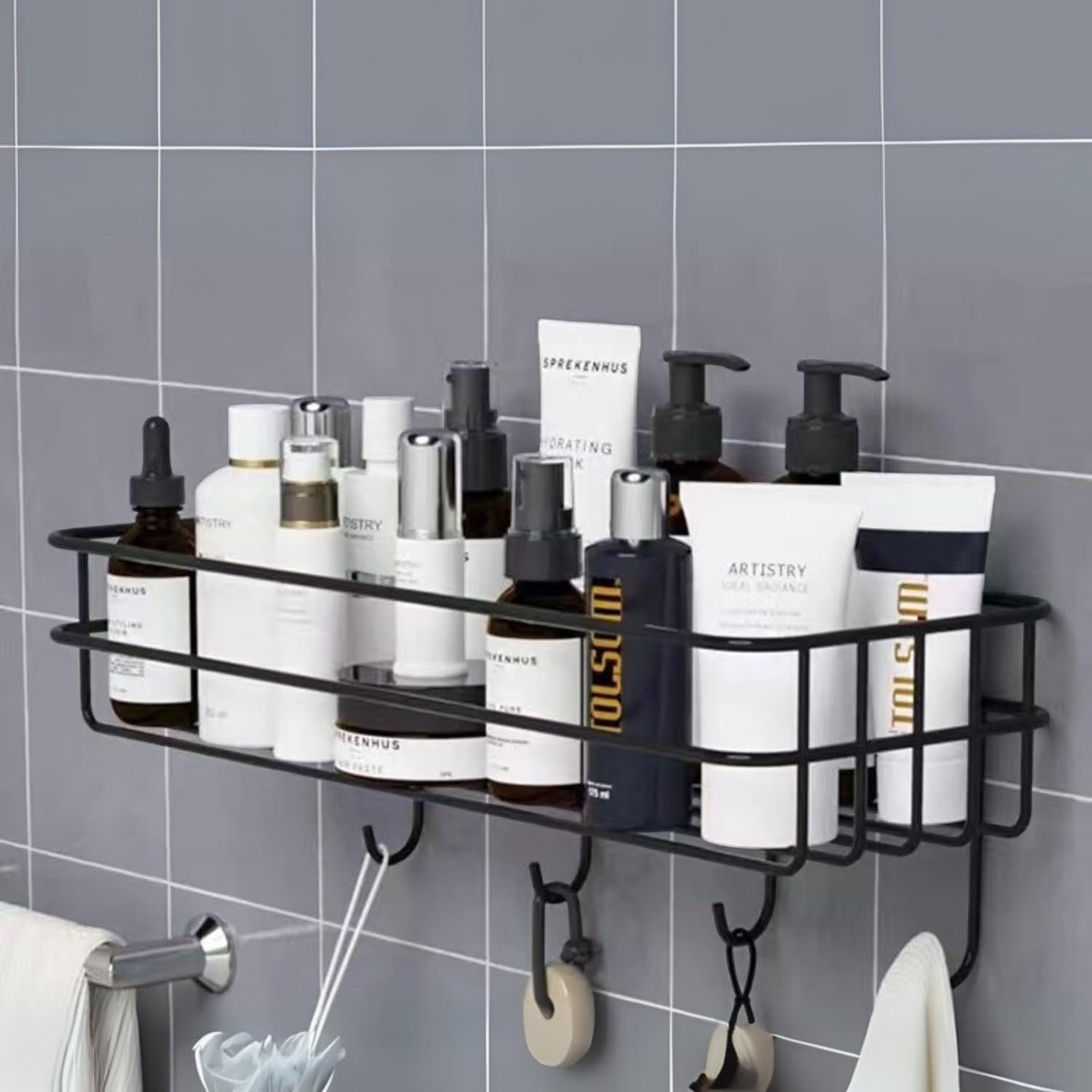 GoHooked black metal bathroom storage basket with hooks, holding various toiletries and bottles. No-drill adhesive installation.