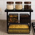 Go Hooked black metal 3-tier rotating storage rack with mesh baskets holding pasta, coffee beans, and rice. Also features glass jars with wooden lids.