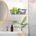 Go Hooked black metal wall mount basket organizer holding toiletries and folded towels.