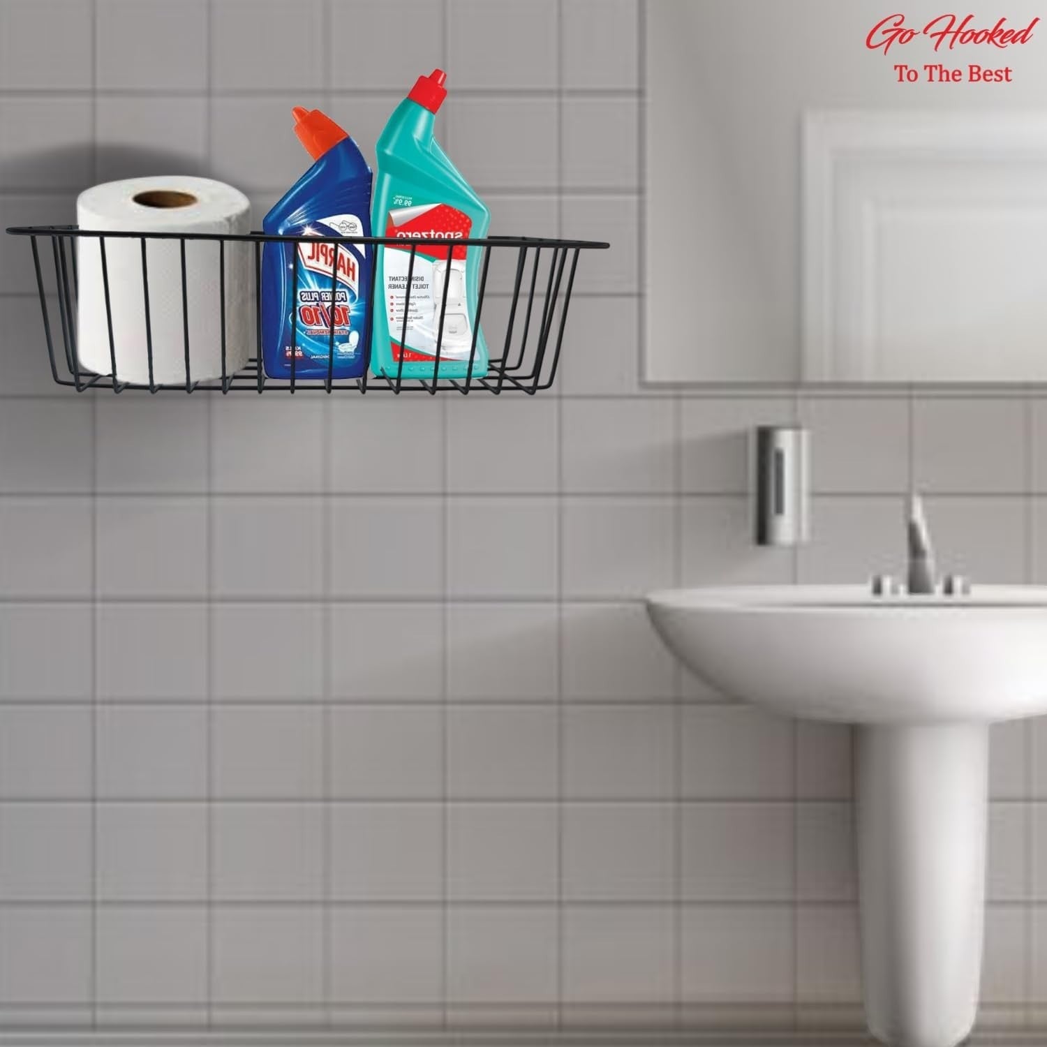 GoHooked black metal wall mount basket holding toilet paper and cleaning supplies in a bathroom.