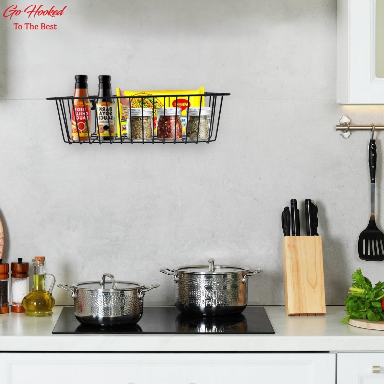 GoHooked black metal wall mount storage basket organizer holding spices and bottles in a kitchen.