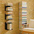 GoHooked black heavy duty metal wall mounted shelves displaying books and a Vogue magazine.