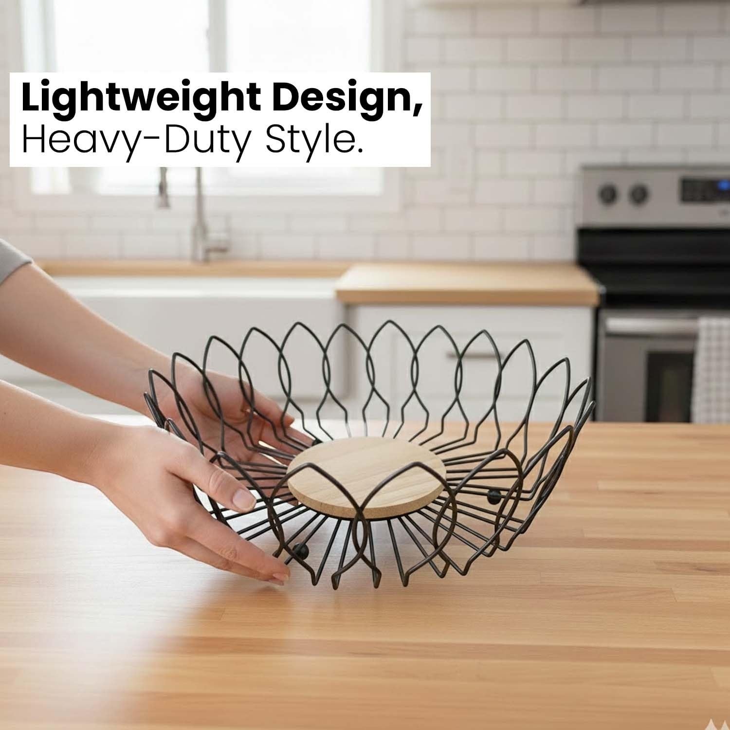 Go Hooked black metal wire fruit basket with a round wooden base, open design for airflow, 10-inch diameter.