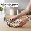 Go Hooked black metal wire fruit basket with a round wooden base, open design for airflow.