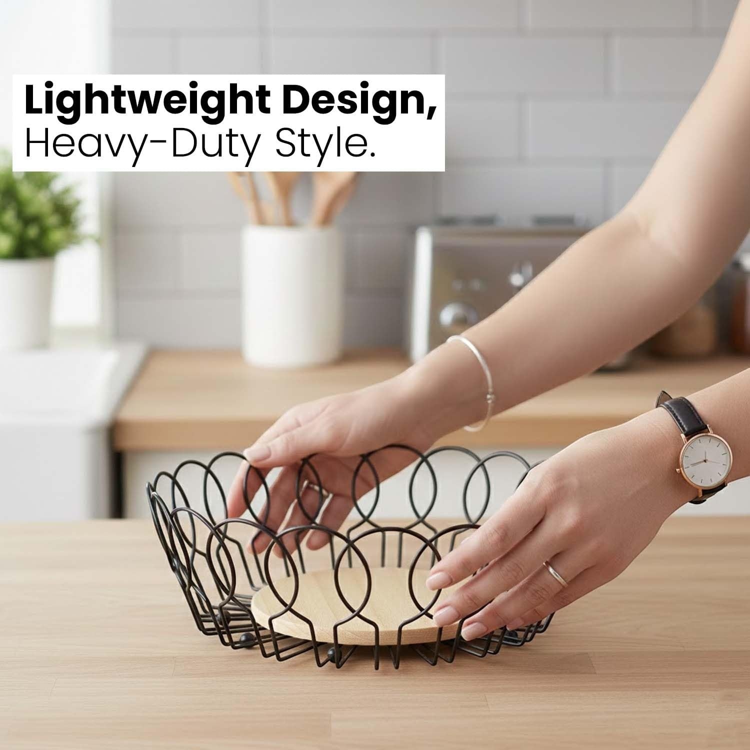 Go Hooked black metal wire fruit basket with a round wooden base, open design for airflow.
