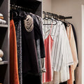 GoHooked black plastic hangers with non-slip grooves holding various garments including dresses, shirts, and coats.