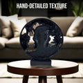 GoHooked black polyresin African lady bust statue with gold feather detailing in a circular frame.