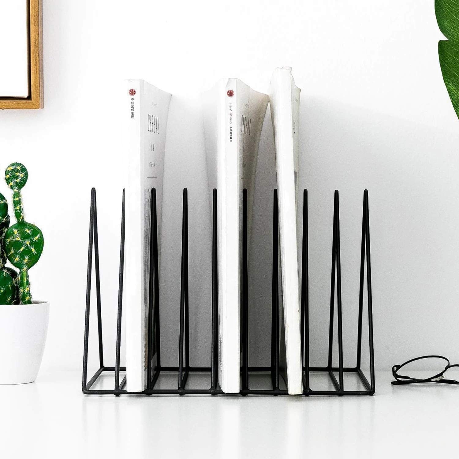 GoHooked black coated steel triangular magazine rack holding books and magazines on a desk.