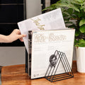 GoHooked black coated steel triangular magazine rack holding vinyl records on a wooden table.