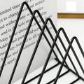 GoHooked black coated steel triangular magazine rack for organizing books and newspapers on a table.