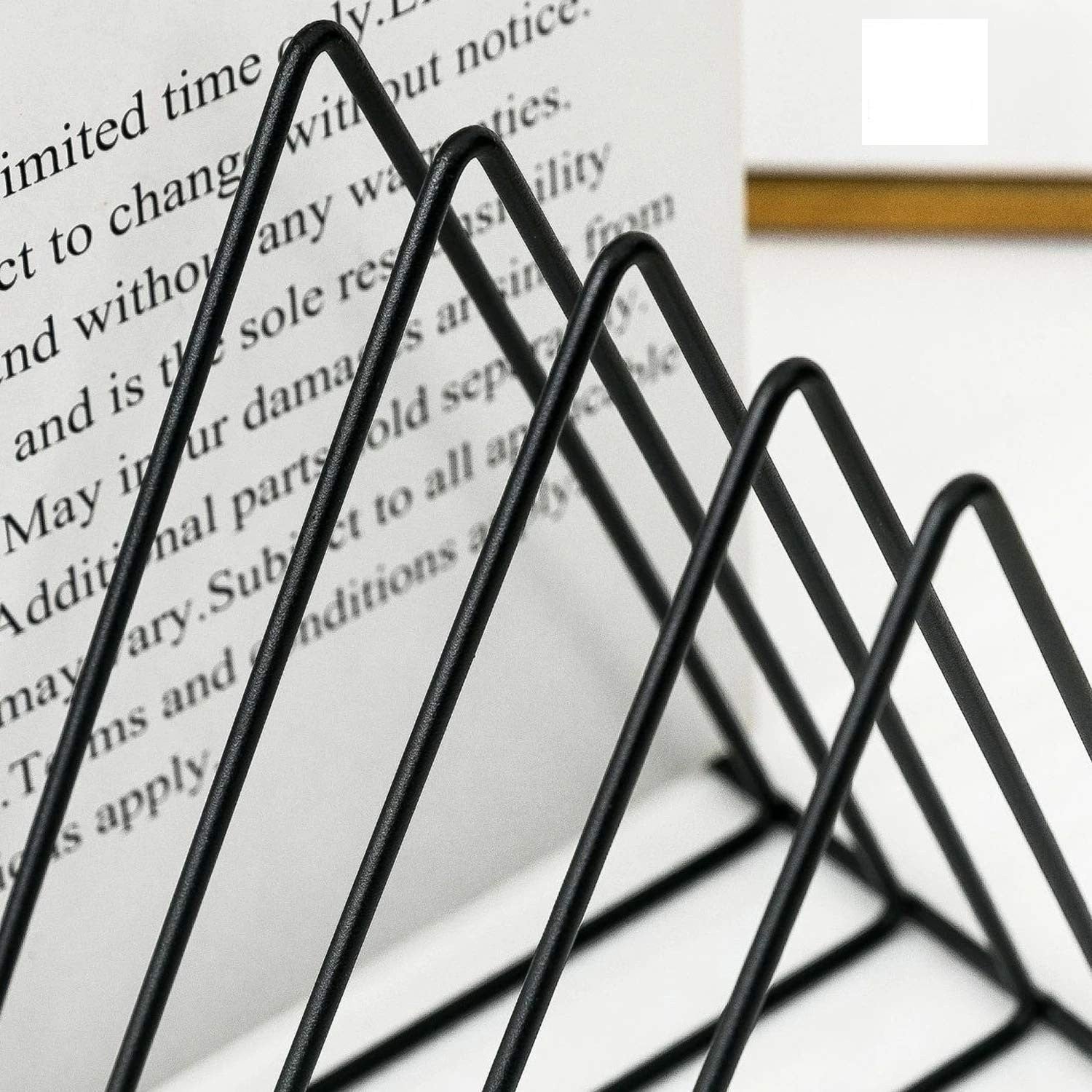 GoHooked black coated steel triangular magazine rack for organizing books and newspapers on a table.