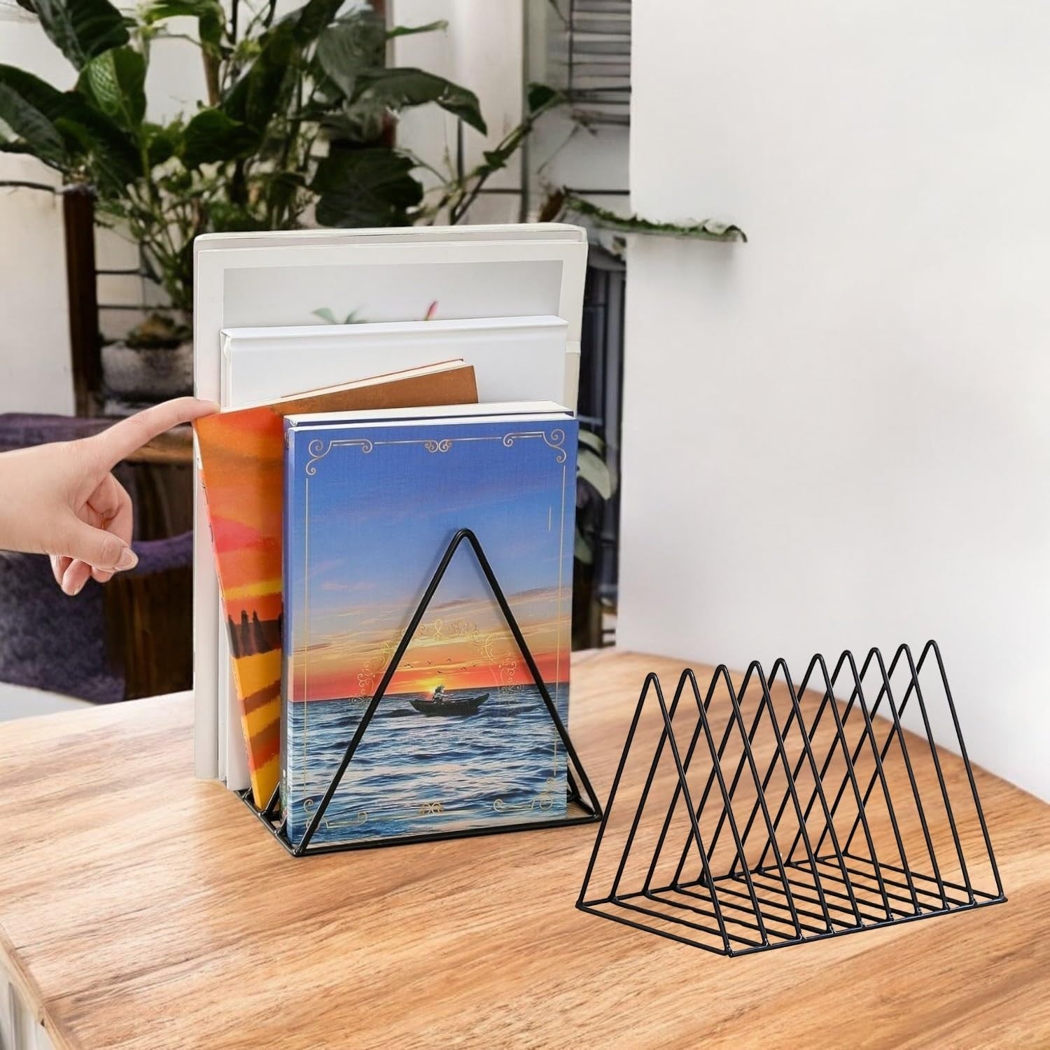 GoHooked black coated steel triangular magazine rack holding books on a wooden desk.