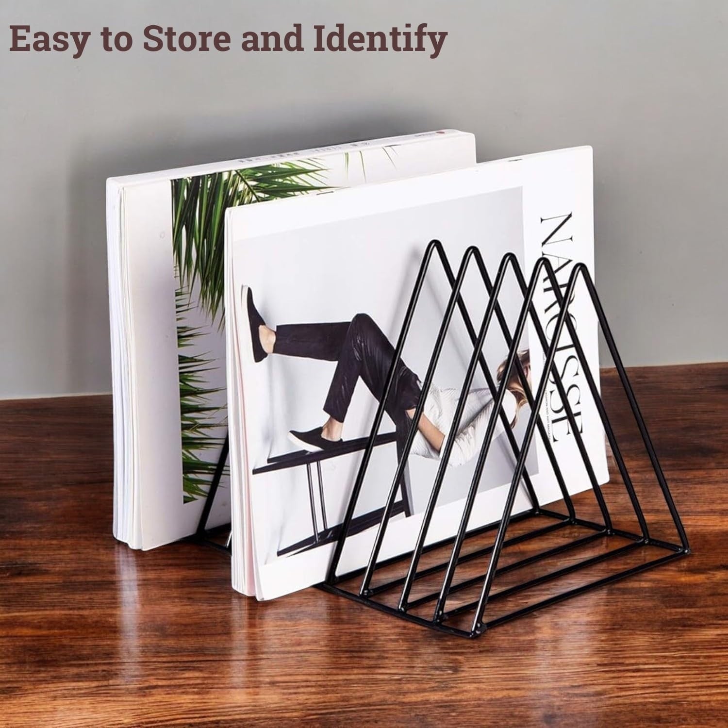 GoHooked black coated steel triangular magazine rack with 9 slots, holding books and magazines on a wooden table.
