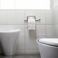 GoHooked black rustproof metal toilet paper holder with self-adhesive installation on a tiled wall.