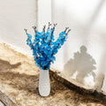 Go Hooked artificial blue blossoms in a white textured ceramic vase, perfect for home or office decor.