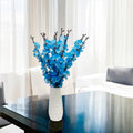 Go Hooked artificial blue blossoms in a white textured vase, a realistic and low-maintenance floral decor.