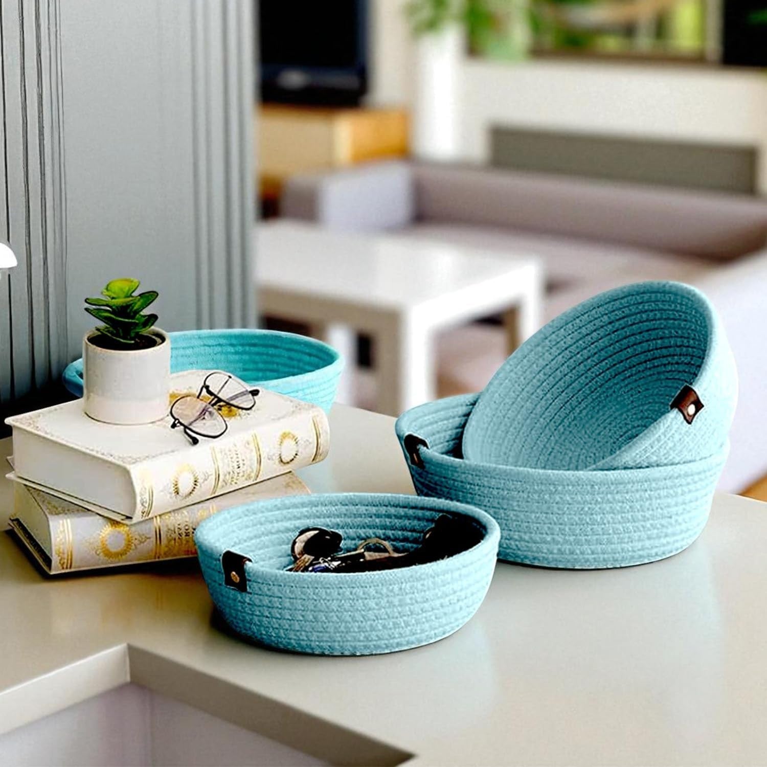 GoHooked set of three light blue round cotton rope storage baskets on a table with books and a small plant