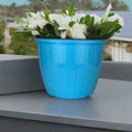 Go Hooked blue plastic Duro flower pot, 10 inch, with vertical ribbed texture, holding white flowers and greenery.