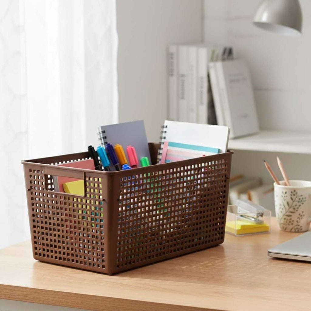 GoHooked brown plastic storage basket with perforated sides, holding notebooks, pens, and sticky notes on a desk.