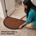 GoHooked semi-circle rubber door mat in royal brown with black border, placed at a home entrance by a woman.