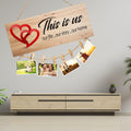 GoHooked brown MDF wood "This is us" sign with red hearts and twine for hanging photos. Rustic farmhouse decor.