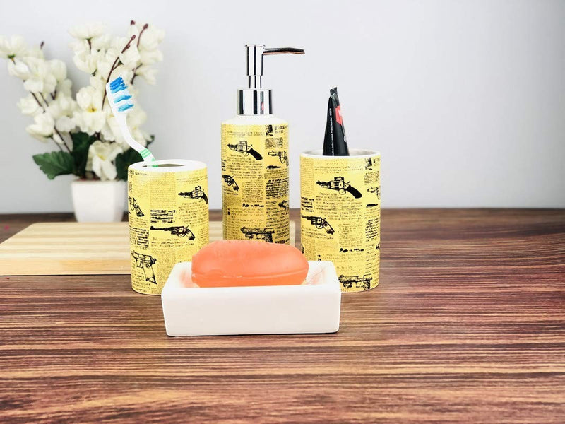 Go Hooked 4-piece ceramic bathroom set in yellow with a newspaper and gun print. Includes soap dispenser, toothbrush holder, tumbler, and soap dish.
