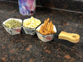 Go Hooked white ceramic serving platter with bamboo handle, divided into 3 sections holding pumpkin seeds, popcorn, and french fries.