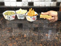 Go Hooked white ceramic snack serving tray with floral pattern, holding pumpkin seeds, popcorn, and french fries.