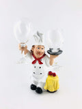 GoHooked white resin chef wine glass holder with red scarf and black shoes, holding two wine glasses.