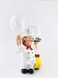 GoHooked white resin chef wine glass holder with red scarf and yellow tablecloth detail. Holds two wine glasses.