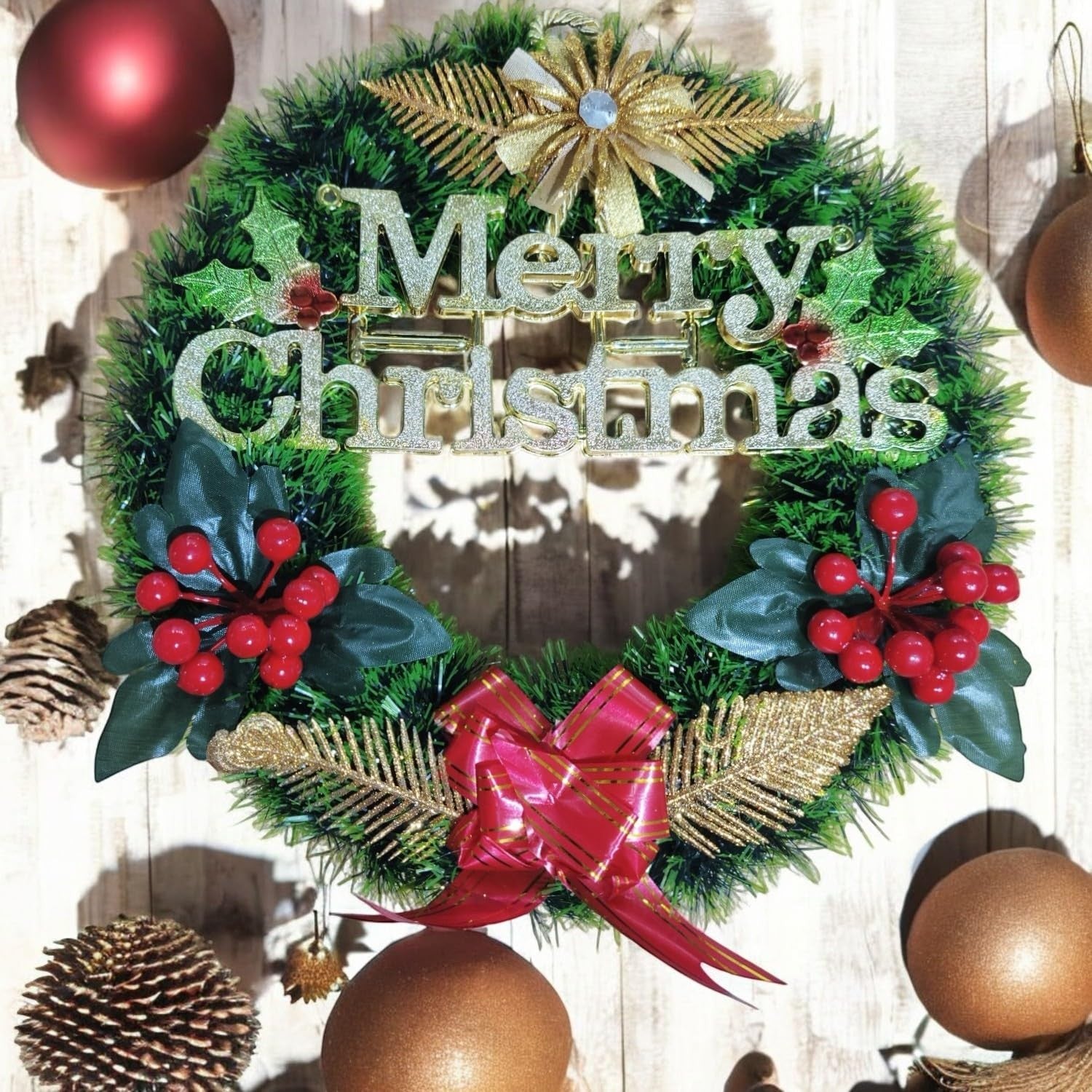 Go Hooked green Christmas wreath with "Merry Christmas" text, red berries, gold accents, and a red bow. Festive decor.