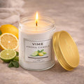 GoHooked white glass jar candle with citrus scent, lit flame, and gold lid. Features lemons and limes.
