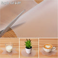 GoHooked clear EVA anti-slip liner being cut with scissors, shown under a glass of milk, a potted plant, and a coffee cup.