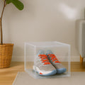 GoHooked clear acrylic shoe box with magnetic front door, displaying grey and blue sneakers with orange laces.