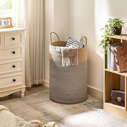 GoHooked two-tone brown and beige cotton rope laundry basket with sturdy handles in a cozy bedroom setting