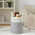 GoHooked cotton rope laundry basket in grey and white with sturdy handles, filled with plush toys in a cozy living room.