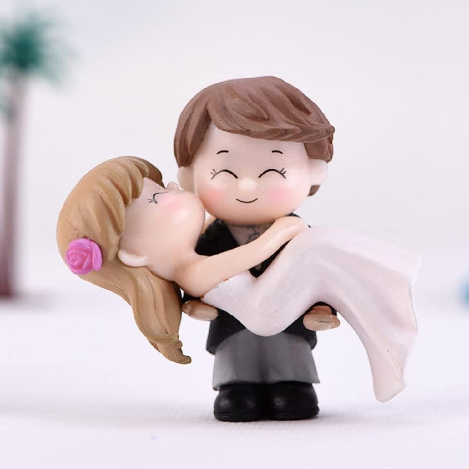 Go Hooked romantic bride and groom figurines in black and white, groom carrying bride with pink rose detail.