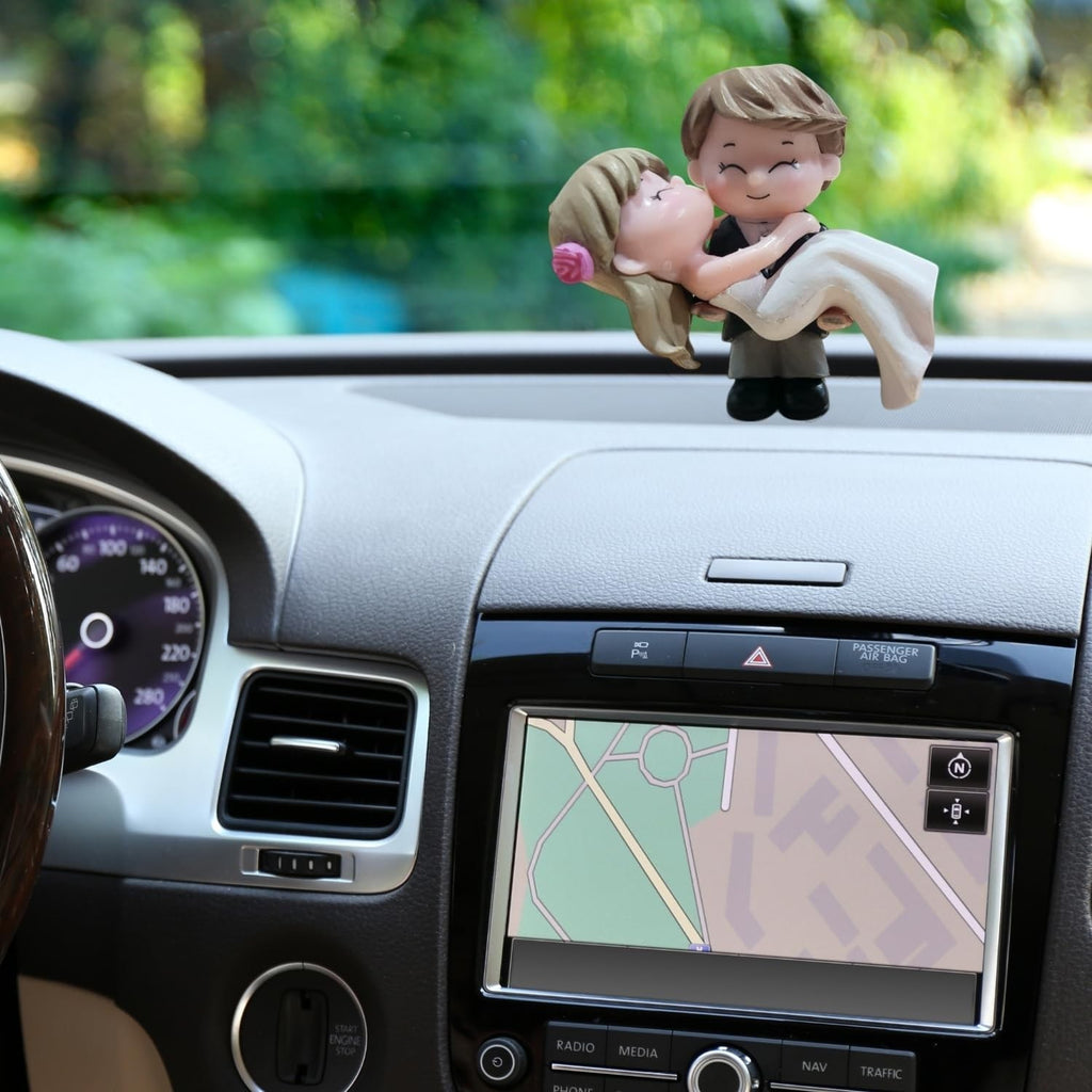 Go Hooked romantic bride and groom figurines in black and white, made of resin, kissing on a car dashboard.