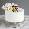 GoHooked romantic couple figurines sitting on a white cake with pink dress doll holding a coffee cup. Resin material.