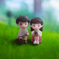 Go Hooked romantic couple figurines, boy in white shirt & brown pants, girl in pink dress holding tea cup, resin material.