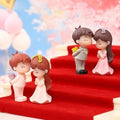 GoHooked resin couple figurines in romantic proposal poses, one holding flowers, for cake decor or gifts.