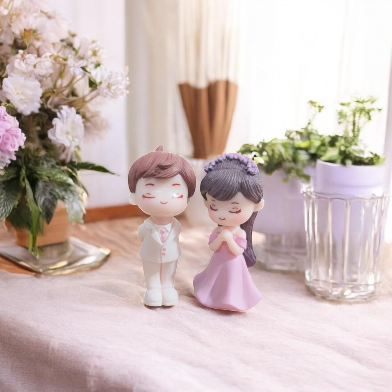 Go Hooked resin couple figurines in proposal pose, groom in white suit, bride in pink dress, for cake decor or home.