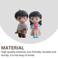 GoHooked romantic couple figurines, one boy in a pink shirt and tan pants, one girl in a blue dress holding a pink cup. Resin material.