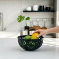 GoHooked dark grey plastic fruit bowl with intricate cutout design, holding apples and a mango.