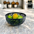 GoHooked dark grey plastic fruit bowl with intricate cut-out design, 21cm wide, holding green and yellow fruits.