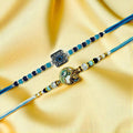 GoHooked set of 2 designer rakhis with blue and silver beads, one featuring a square evil eye charm and the other a gold-tone deity.