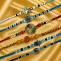 GoHooked set of 6 designer rakhis with pearl beads, peacock, hamsa hand, and evil eye charms on gold satin.