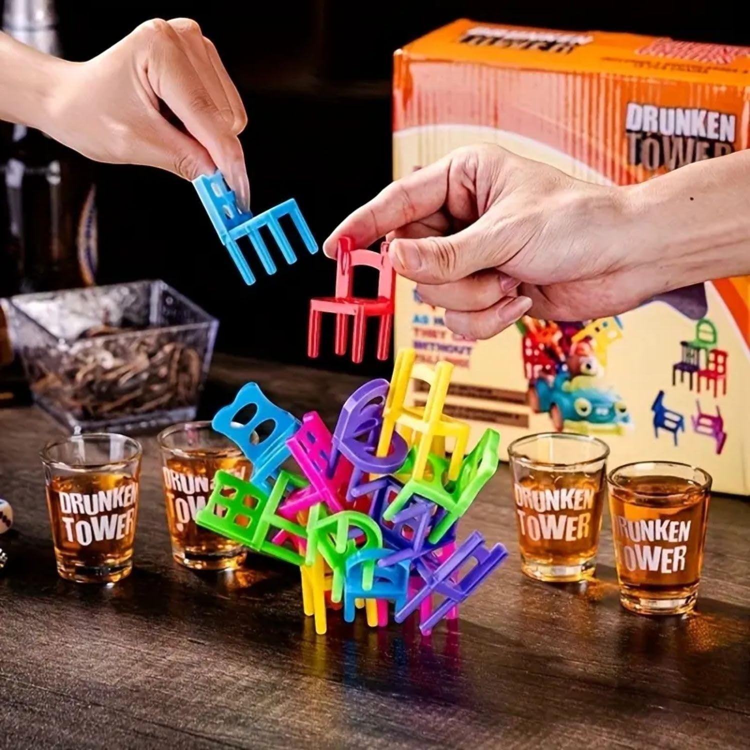 GoHooked colorful plastic chairs stacked precariously with shot glasses on a wooden table, a fun drinking game.
