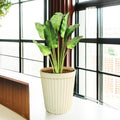 Go Hooked Eiffel Tower 14-inch round plastic planter pot with vertical stripe pattern, beige and off-white.